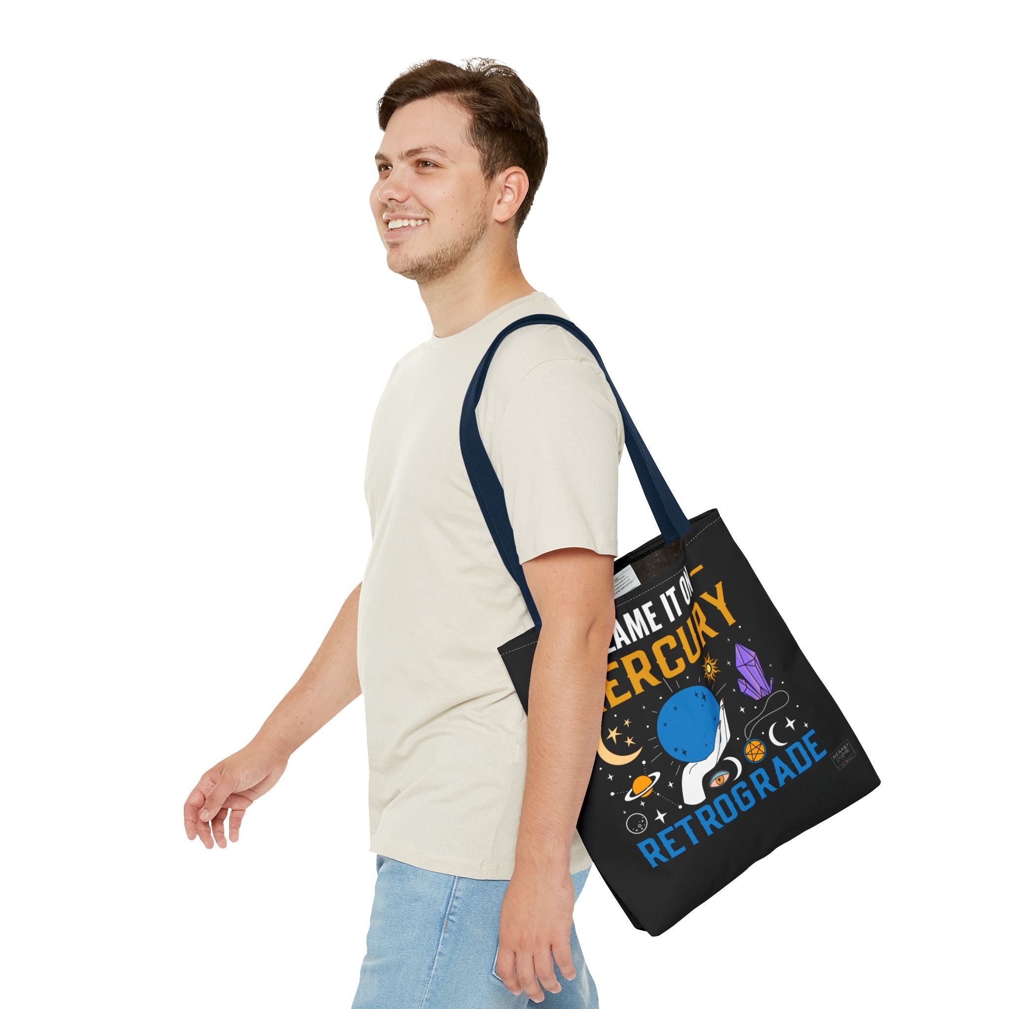 Man holding navy retrograde tote with soft smirk and relaxed style