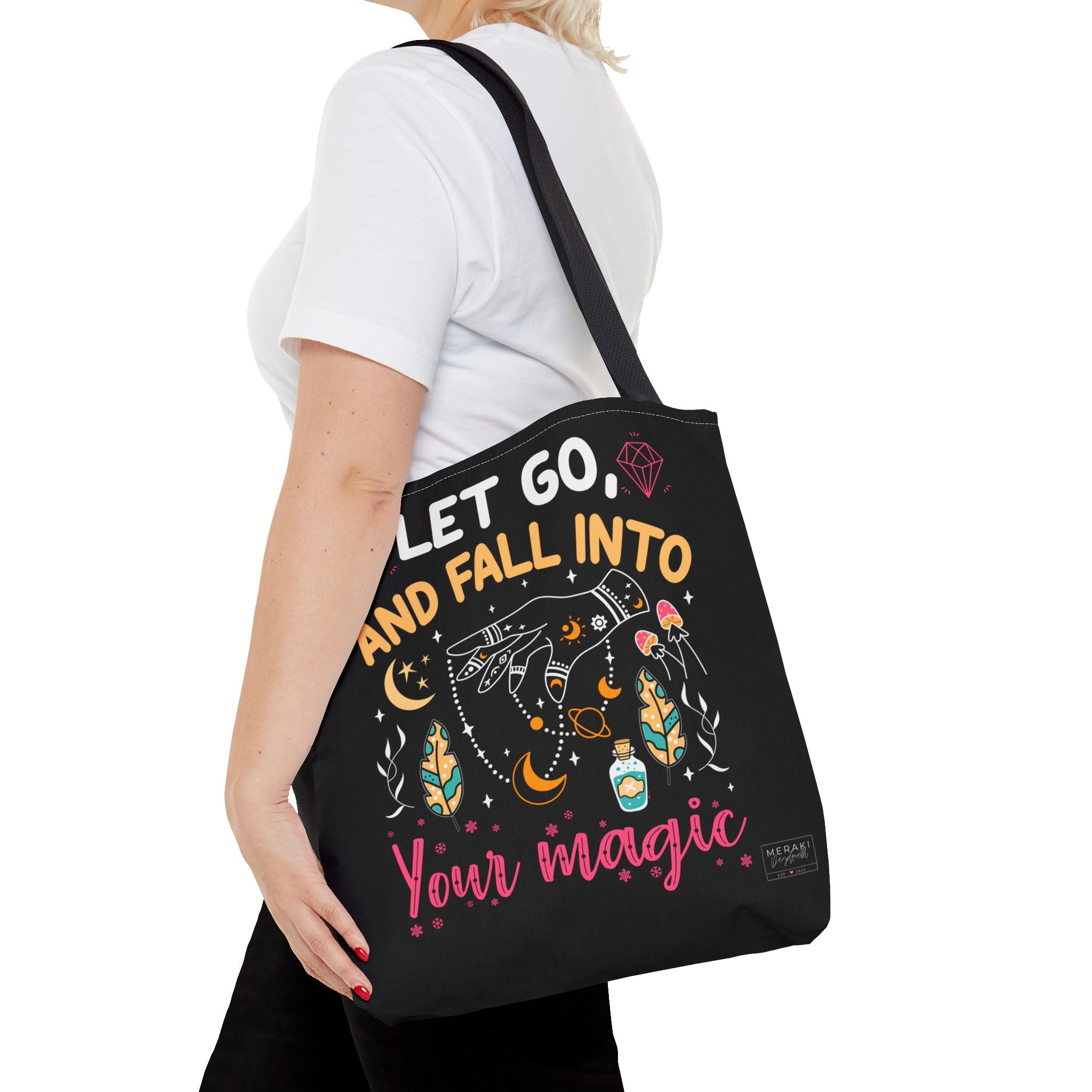 Woman holding Fall Into Your Magic tote bag