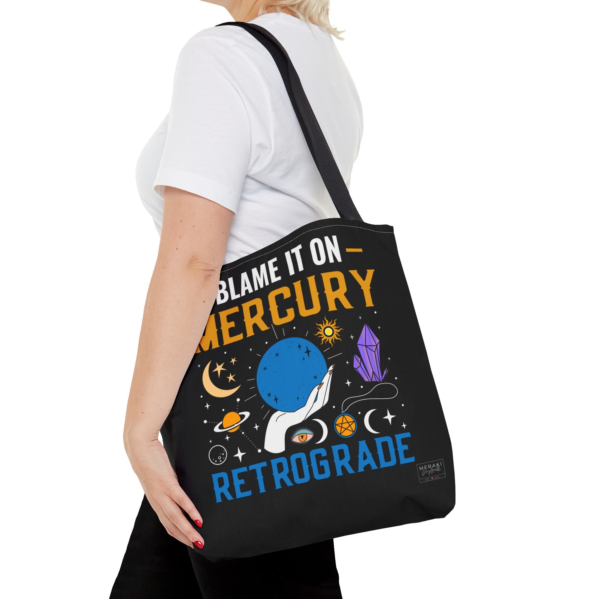 Woman wearing black handle Mercury retrograde tote on shoulder outdoors