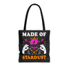 Front view of Made of Stardust tote bag with black handles and cosmic text
