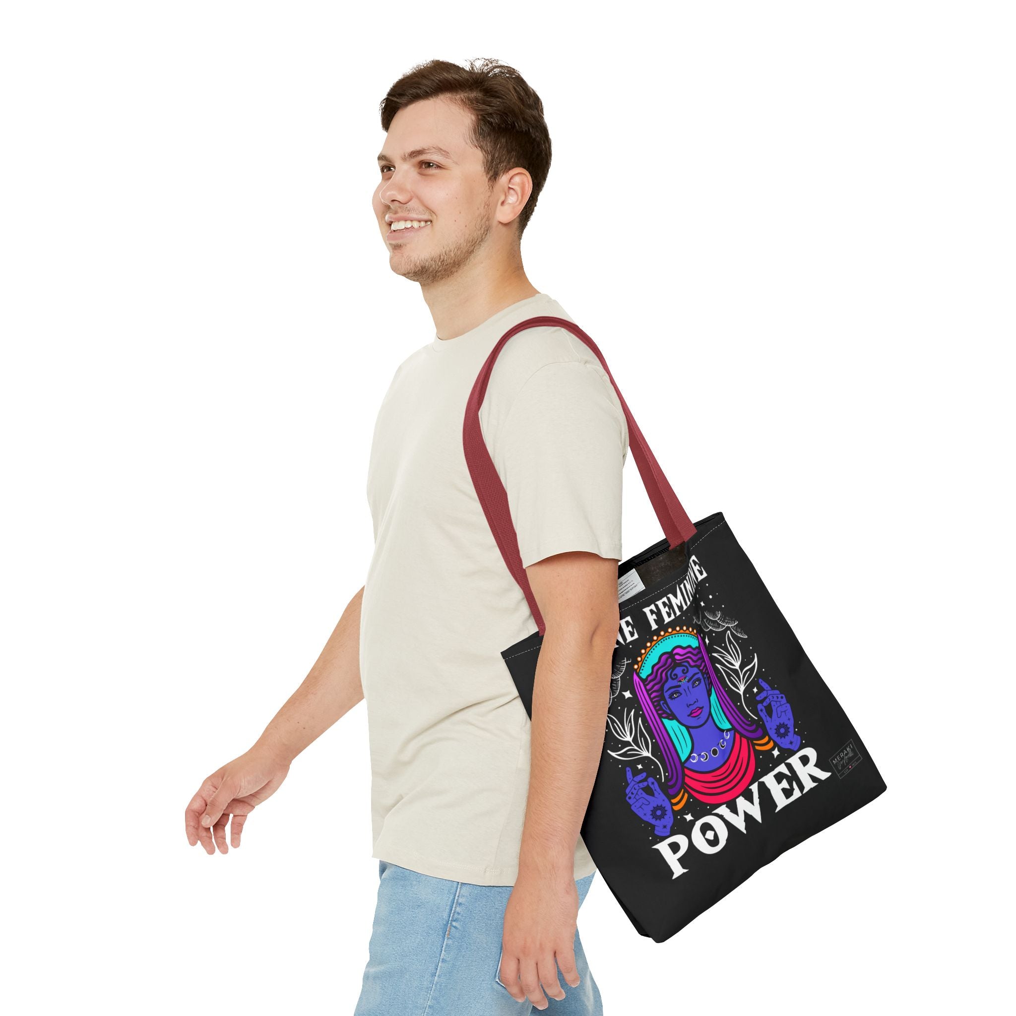 Man wearing Divine Feminine Power tote bag with red handles and casual outfit