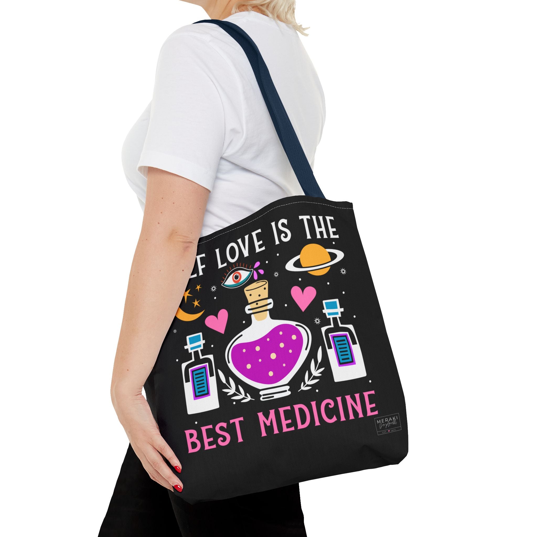 Woman carrying navy handle tote with candle, journal, and water bottle