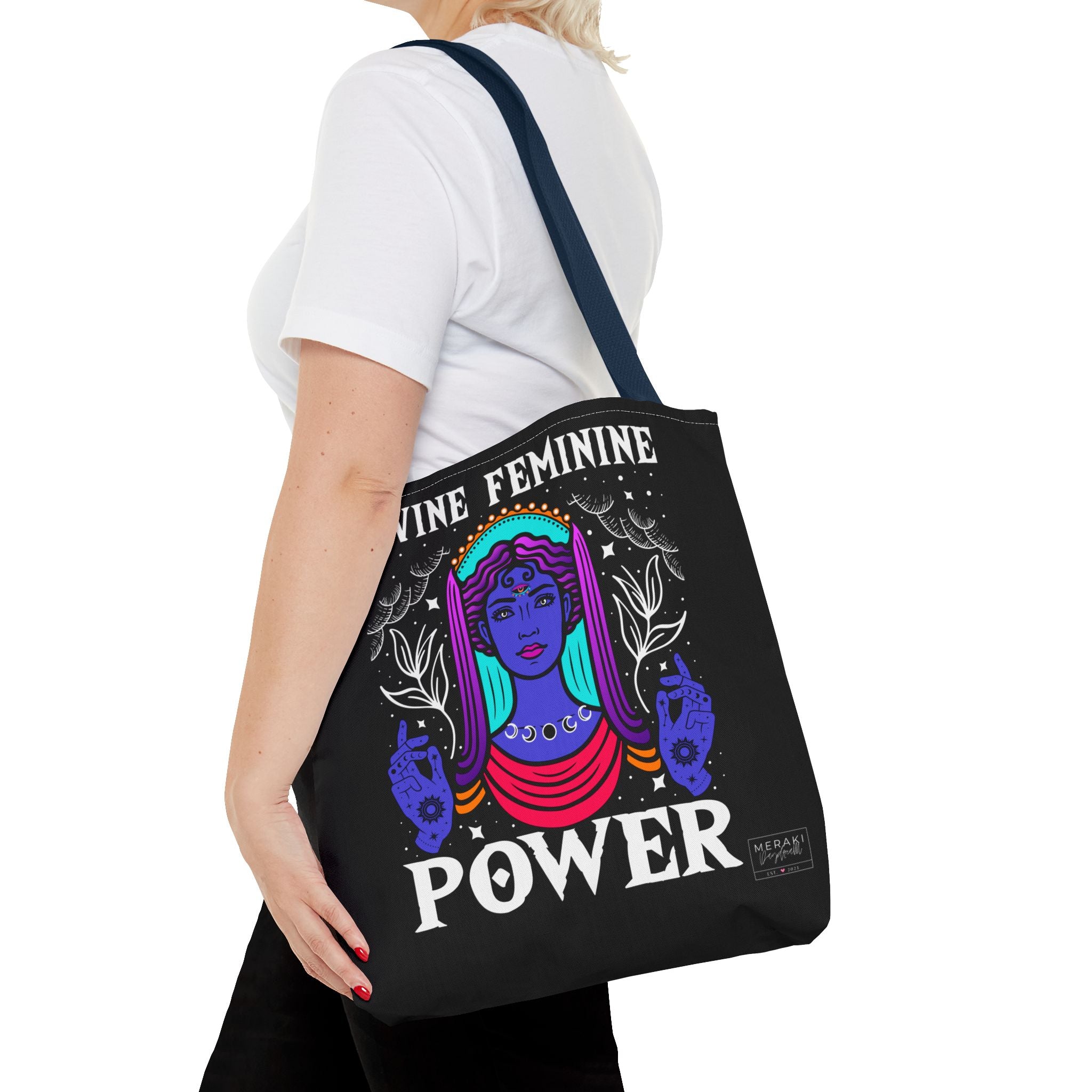 Woman with navy blue handle tote walking through city in calm feminine style
